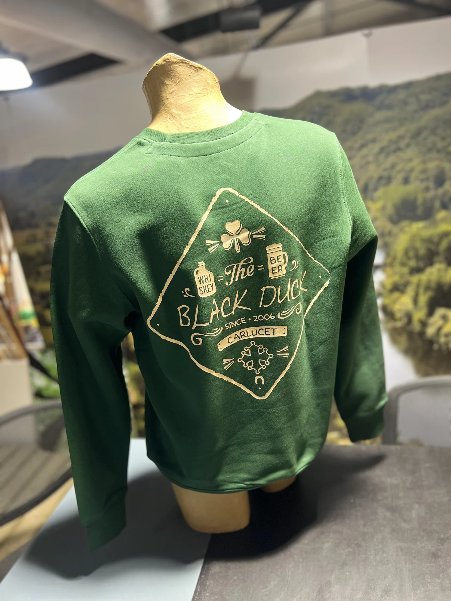 Dos d'un sweat vert The Black Duck avec le grand visuel crème imprimé en DTF