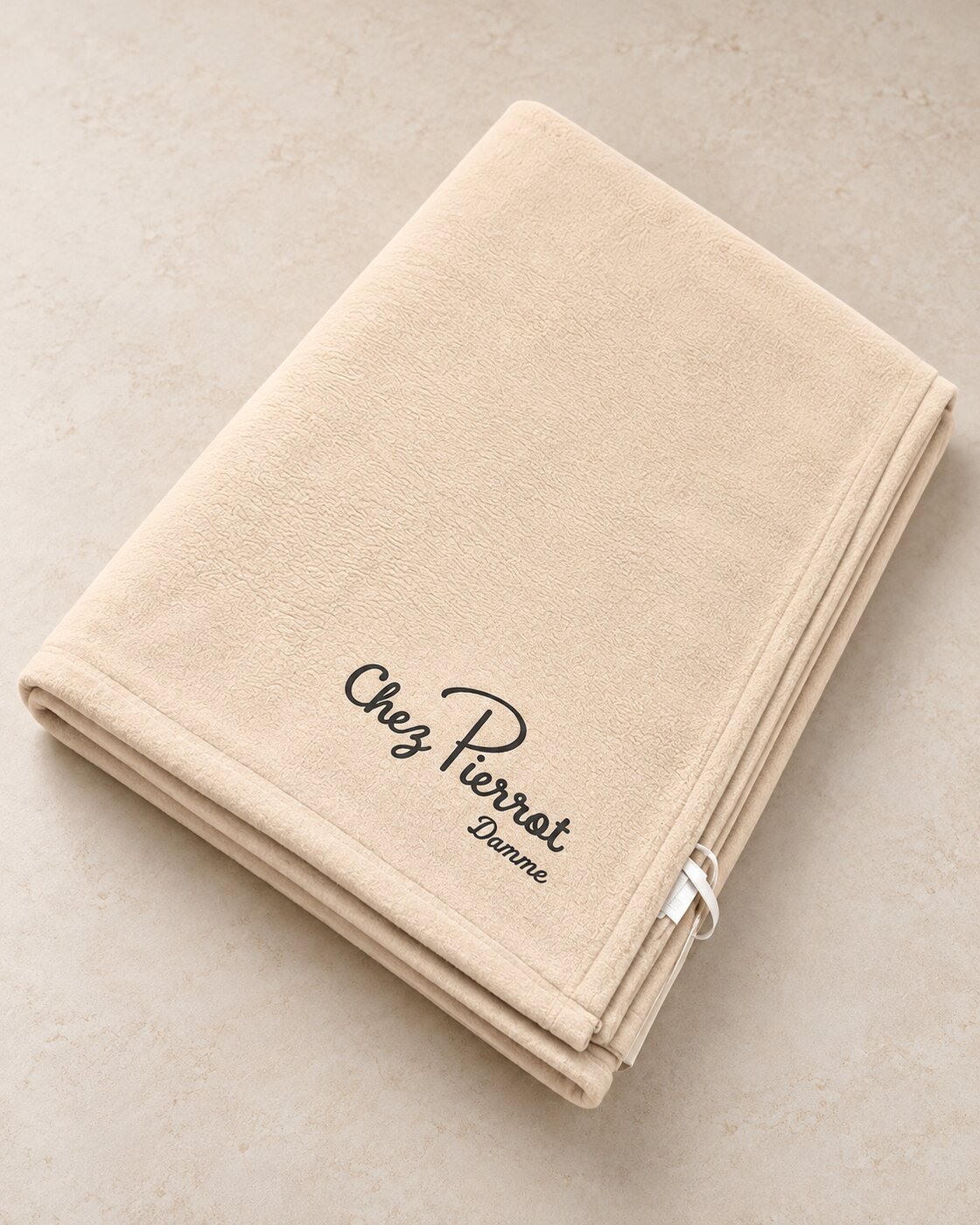 Plaid polaire beige plié, logo Chez Pierrot imprimé en DTF dans le coin