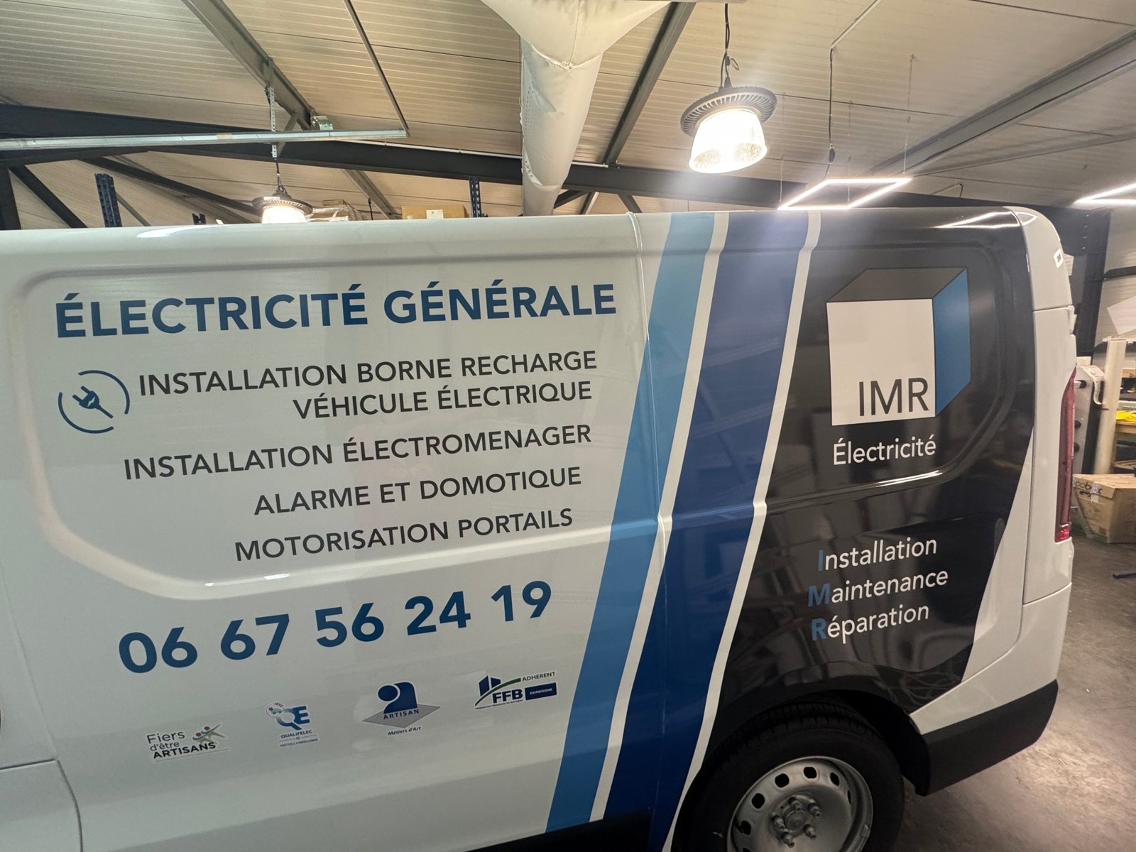 Flanc du Trafic IMR Électricité : liste des prestations, téléphone, labels et bandes bleues et noires en adhésif