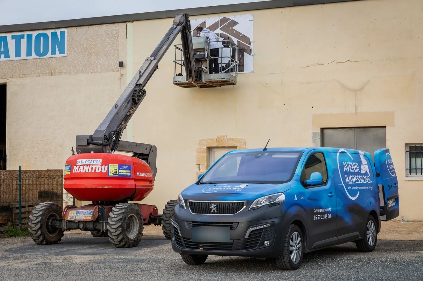 Gabarit papier du logo ML Studio fixé sur la façade, vu depuis la nacelle
