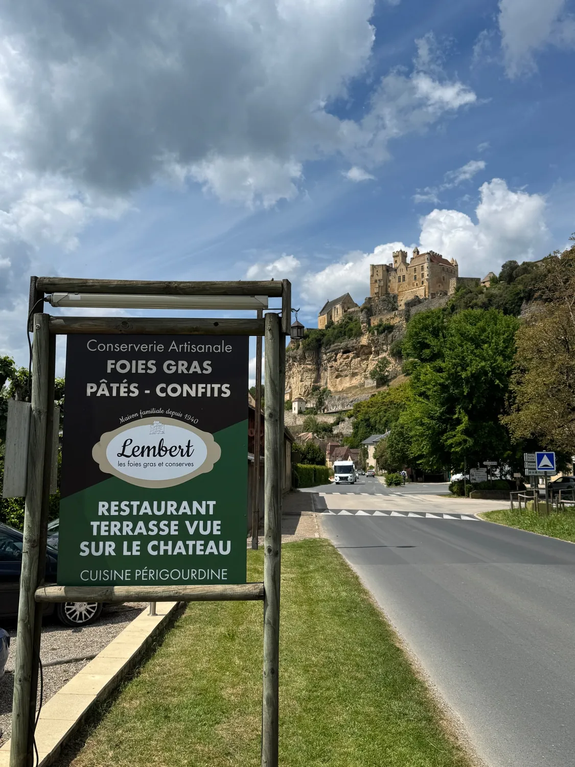 Panneau de bord de route de la Maison Lembert pour le restaurant et sa terrasse, avec le château de Beynac en arrière-plan